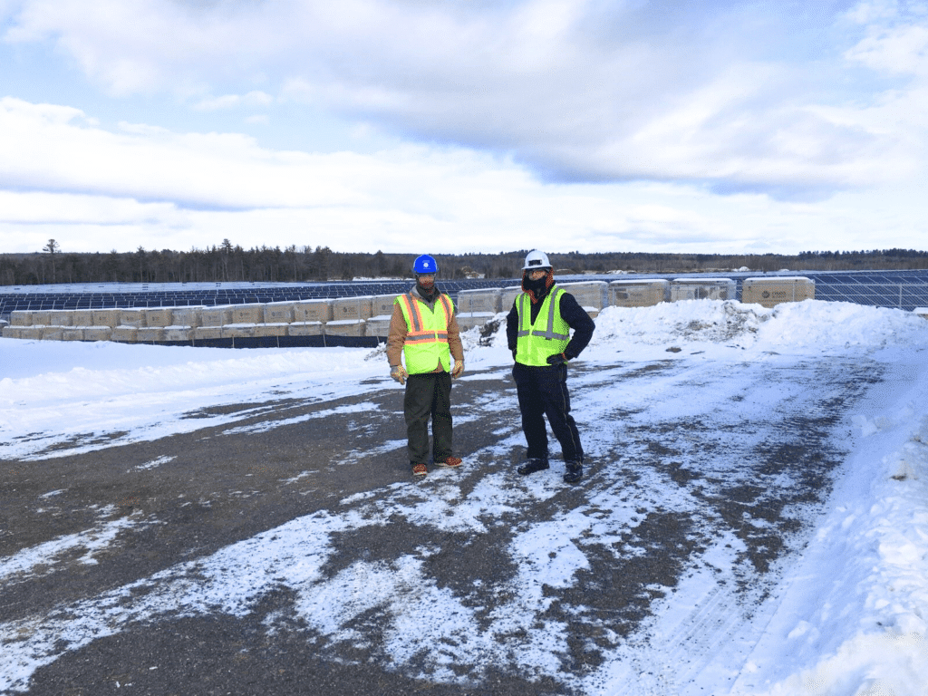 Two Tradesmen in High Visibility PPE Standing at a Solar Site